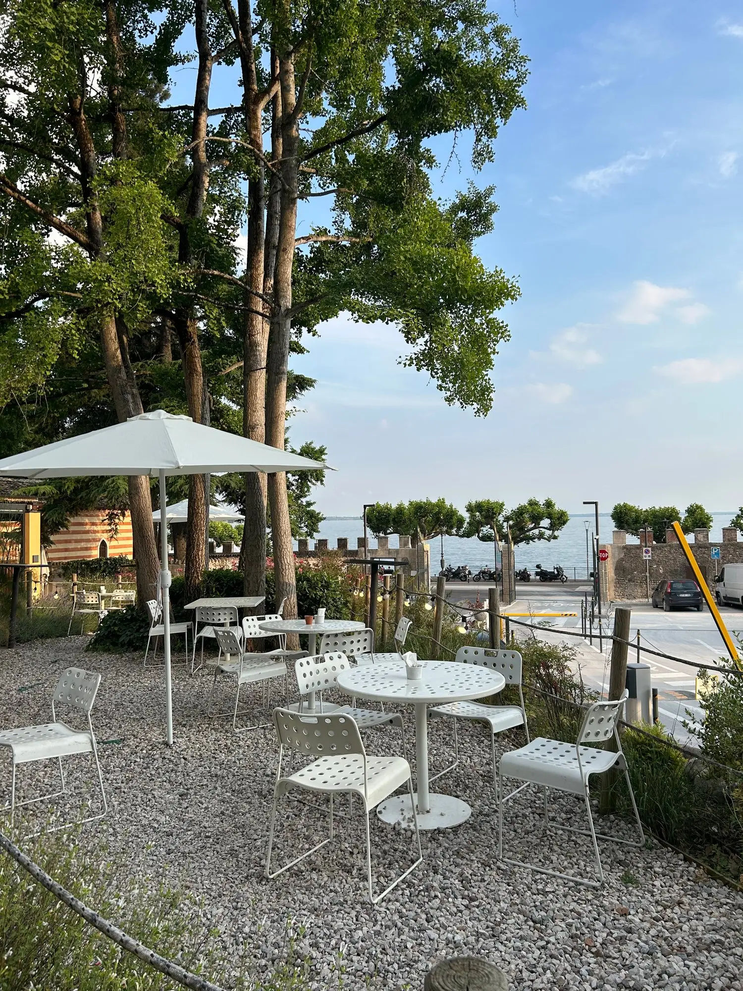 Un tavolino in terrazza tra gli alberi nella calda luce del pomeriggio